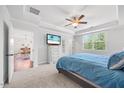 Bright main bedroom boasts a ceiling fan, a TV, and a trey ceiling above the bed with blue linens at 247 Axis Deer Ln, Garner, NC 27529