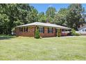 Charming brick home on a lush green lawn surrounded by mature trees, offering privacy and curb appeal at 28 White Oak Dr, Smithfield, NC 27577