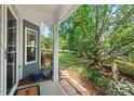 Welcoming front porch with a stone walkway, landscaped garden, and a peek of the expansive yard at 3002 Bartlett Cir, Hillsborough, NC 27278