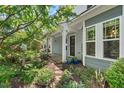Inviting front porch and garden pathway, surrounded by lush greenery and natural light at 3002 Bartlett Cir, Hillsborough, NC 27278
