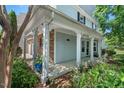 Covered front porch supported by white columns, complemented by lush greenery and stone accents at 3002 Bartlett Cir, Hillsborough, NC 27278