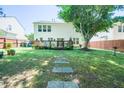 Spacious backyard with mature tree, patio, and a stone paver path at 3016 Hayling Dr, Raleigh, NC 27610