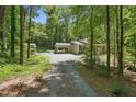 Gravel driveway leading to a charming home nestled among lush green trees at 305 Old School Rd, Chapel Hill, NC 27516