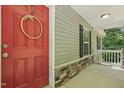 Close-up of a red front door with a decorative wreath and stone accents on the front porch at 305 Old School Rd, Chapel Hill, NC 27516