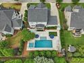 Aerial view of a backyard oasis featuring a pool, hot tub, patio, and lush landscaping at 305 Springtree Circle Cir, Fuquay Varina, NC 27526