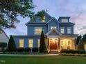 Beautiful two-story home with well-manicured lawn and a welcoming front porch at dusk at 305 Springtree Circle Cir, Fuquay Varina, NC 27526