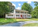 A spacious two-story white home with black shutters, a manicured lawn, and a stone driveway at 307 Country Club Dr, Durham, NC 27712