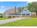 Charming exterior view of a two-story home with a welcoming front porch and well-maintained landscaping at 314 Lane Rd, Dunn, NC 28334