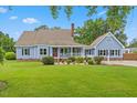 Charming two-story home featuring a well-manicured lawn, inviting front porch, and classic architectural details at 314 Lane Rd, Dunn, NC 28334