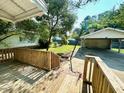 View from the wooden porch to the backyard with grass and a detached garage at 3810 Pendergrass St, Durham, NC 27704