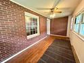 Bright sunroom with brick walls, hardwood floors, and multiple windows for natural light at 3810 Pendergrass St, Durham, NC 27704