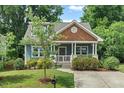 Charming blue craftsman home with a welcoming front porch, manicured landscaping and mature trees at 415 Dupree St, Durham, NC 27707