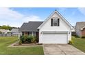 A white home with a two-car garage, complimented by green grass, and an eye-catching tree at 4408 Jordan Oaks Way, Raleigh, NC 27604
