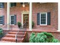 Close-up of the front entrance showing the brick steps, columns, and wooden door with decorative wreath at 4521 Chicopee Trl, Durham, NC 27707