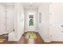 Inviting entryway with hardwood floors, a decorative rug, and views of the front yard through a glass door at 47 Coventry Ln, Chapel Hill, NC 27516