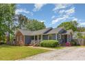 View of home featuring brick and siding, landscaped yard, and cozy front porch, creating a welcoming curb appeal at 500 Hunters Ridge Dr, Fuquay Varina, NC 27526
