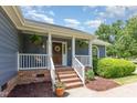 Close up of front porch with brick steps and columns and a wreath on front door at 500 Hunters Ridge Dr, Fuquay Varina, NC 27526