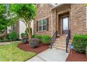 Close-up of home's front door with stone facade, manicured landscaping, and security system at 5003 Blue Jack Oak Dr, Cary, NC 27519