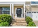 Inviting front entrance with stone steps, columns, and decorative black railings at 5011 Peachtree Town Ln, Knightdale, NC 27545