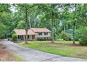 Traditional two-story home with a welcoming front porch, long driveway, and mature trees offering great shade at 5121 Raintree Rd, Durham, NC 27712