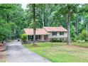 Traditional two-story home with a welcoming front porch and a long driveway surrounded by mature trees at 5121 Raintree Rd, Durham, NC 27712