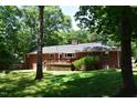Spacious backyard featuring a wooden deck perfect for outdoor dining and entertaining, surrounded by mature trees at 515 Wildwood Dr, Durham, NC 27712