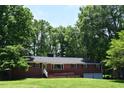 Beautiful red brick home with a well-manicured lawn and mature trees in a peaceful, wooded neighborhood at 515 Wildwood Dr, Durham, NC 27712