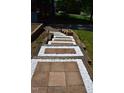 Stone and brick pathway leading to the house, surrounded by lush greenery and decorative white stones at 515 Wildwood Dr, Durham, NC 27712