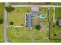 Aerial view of home surrounded by large grassy yard including pool, outbuilding and multi-car parking at 5200 Pulley Town Rd, Zebulon, NC 27597