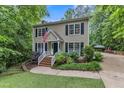 Charming two-story home with wood siding, black shutters, manicured lawn, and an American flag at 5805 Bayberry Ln, Raleigh, NC 27612