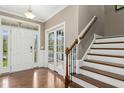 Bright foyer with hardwood floors, staircase and entry doors with transom windows allowing natural light at 6444 Kit Creek Rd, Morrisville, NC 27560
