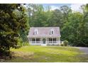 Beautiful home surrounded by lush greenery with a well-maintained lawn and a charming front porch at 657 Lakeview Dr, Stem, NC 27581
