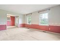 Spacious living room featuring carpet, light walls, and large windows offering natural light at 6909 Hickory Dr, Raleigh, NC 27603