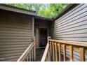 Close-up of the home's front entrance with a rustic wooden door, complemented by a wooden walkway and handrails at 73 Stoneridge Rd, Durham, NC 27705