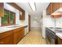Functional kitchen features wood cabinets, white appliances and a pass-through to a bright dining space at 73 Stoneridge Rd, Durham, NC 27705