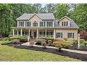 Inviting two-story home with manicured landscaping, covered porch, and classic architectural details at 7811 Still Crossing Rd, Chapel Hill, NC 27516