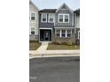 Attractive townhouse exterior features a stone and siding facade with landscaped lawn at 803 Courting St, Apex, NC 27523
