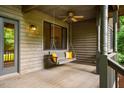 Relaxing porch featuring a swing, ceiling fan, and views of the serene surroundings at 8821 Oconee Ct, Chapel Hill, NC 27516