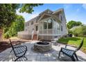 Backyard featuring a cozy fire pit with chairs, a deck, and a sunroom perfect for entertaining at 100 Maywood Way, Chapel Hill, NC 27516