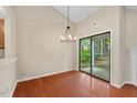 Bright dining area with hardwood floors, a modern chandelier, and sliding glass door to outdoors at 1014 Laurens Way, Knightdale, NC 27545