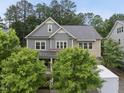 Charming two-story home with trees and a driveway featuring a white trailer for moving at 1029 Dozier Way, Cary, NC 27518