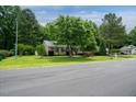Charming home with mature trees, manicured lawn, and lush landscaping creating a serene and inviting curb appeal at 117 Rack Ct, Willow Springs, NC 27592