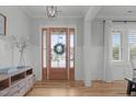 Bright entryway with wood floors and a beautifully decorated glass front door at 120 Hazel Alder Ct, Holly Springs, NC 27540
