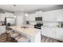 Bright kitchen with white cabinets, stainless steel appliances, granite countertops, and large center island at 1213 Everton Ave, Durham, NC 27703