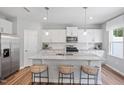 Bright kitchen featuring stainless steel appliances, white cabinets, granite countertops, and a large center island at 1213 Everton Ave, Durham, NC 27703