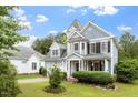 Captivating view of a stylish blue house with a well-maintained lawn and mature trees at 1217 Heritage Greens Dr, Wake Forest, NC 27587