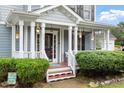 Inviting front porch with decorated entrance, lush shrubbery, and well-manicured landscaping at 1217 Heritage Greens Dr, Wake Forest, NC 27587