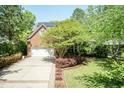 Beautiful home showcasing a large driveway leading to the two-car garage, complemented by mature landscaping at 126 Solterra Way, Durham, NC 27705