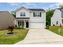 Charming two-story home featuring a well-manicured lawn, two-car garage and inviting front porch at 150 Sherrill Place Ln, Garner, NC 27529