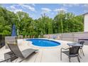 Relaxing kidney-shaped pool surrounded by lush trees and lounge chairs, creating a tranquil outdoor oasis at 150 Sherrill Place Ln, Garner, NC 27529